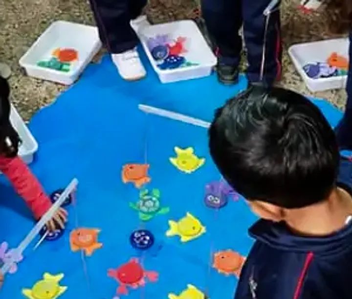 El juego de pesca: una alfombra azul con peces de colores y las cañas